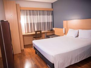 a bedroom with a bed and a desk and a window at ibis Itu Plaza Shopping in Itu
