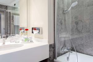 a bathroom with a shower and a sink at NH Collection Köln Mediapark in Cologne