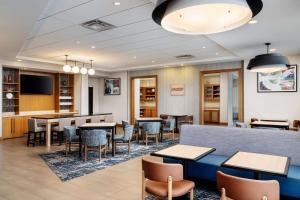 a restaurant with tables and chairs and a tv at Hyatt Place Canton in Lake Cable