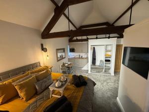 a living room with a couch and a tv at The Old Stables in Northampton