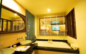 y baño con bañera, 2 lavabos y espejo. en Khaolak Orchid Beach Resort - SHA Extra Plus, en Khao Lak