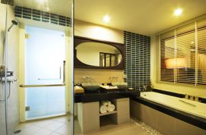 y baño con lavabo, bañera y espejo. en Khaolak Orchid Beach Resort - SHA Extra Plus en Khao Lak