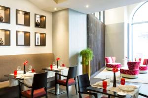 un ristorante con tavoli e sedie e una finestra di NH Collection Brussels Centre a Bruxelles