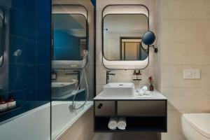 y baño con lavabo y espejo. en NH Collection Frankfurt Spin Tower, en Frankfurt