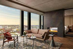 a living room with a couch and a fireplace at NH Collection Frankfurt Spin Tower in Frankfurt/Main