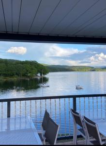a balcony with a view of a lake with a table and chairs at LES TERRASSES DU LAC in Chaumard
