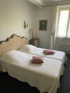 - une chambre avec 2 lits avec des draps blancs et une fenêtre dans l'établissement Residence le Petit Paradis, à Labastide-Rouairoux
