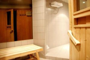 y baño con ducha y banco. en NH Gent Belfort en Gante