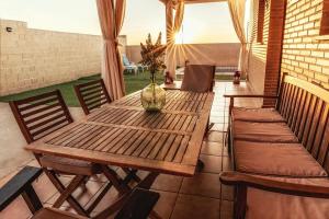 - une table en bois avec des chaises et un vase sur la terrasse dans l'établissement Casa Miragredos, a solo 5 min de Puy du Fou y Toledo, à Cobisa