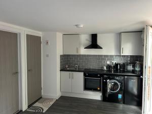 a kitchen with a washer and a sink and a dishwasher at ChaRloHub 01 in Coventry