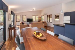 a kitchen and living room with a bowl of fruit on a table at Cape Illawarra Holiday House Margaret River in Margaret River Town