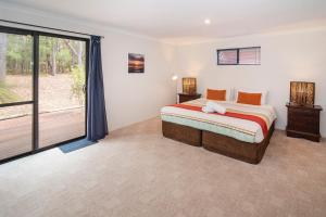 a bedroom with a bed and a large window at Cape Illawarra Holiday House Margaret River in Margaret River Town