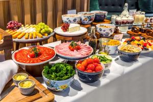 einen Tisch mit vielen Teller mit Lebensmitteln und Schalen mit Gemüse in der Unterkunft nhow London in London