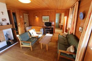 ein Wohnzimmer mit einem Sofa und einem Tisch in der Unterkunft Arnica 1 in Chateau-d'Oex