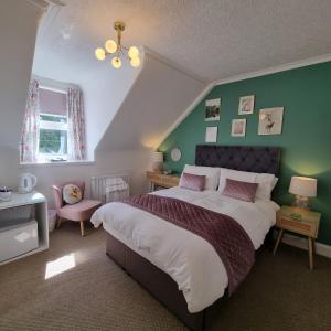 1 dormitorio con cama y pared verde en Rose Villa en Oban