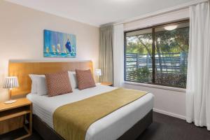 a bedroom with a large bed and a window at Club Wyndham Seven Mile Beach, Trademark Collection by Wyndham in Cambridge