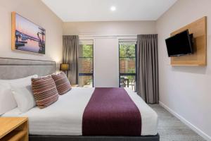 a hotel room with a bed and a flat screen tv at Club Wyndham Seven Mile Beach, Trademark Collection by Wyndham in Cambridge