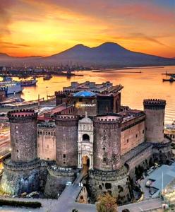 un antico castello con un tramonto sullo sfondo di Residence Torre Giuseppina a Napoli