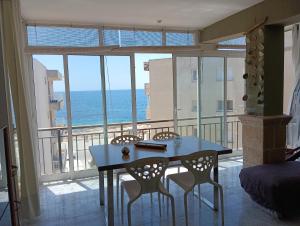 a dining room with a table and chairs and the ocean at ADRIJUL in Moraira
