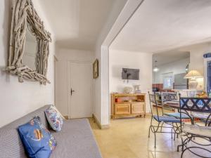 Una sala de estar con un sofá y una mesa con sillas. en Apartment Lou Jas by Interhome, en Saint-Cyr-sur-Mer