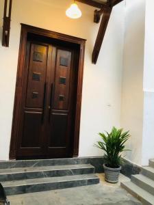 a wooden door with stairs in front of a building at Villa365 in Godagama