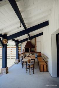 a patio with a table and chairs and a stove at La Maison de Marie in Saint-Julien-en-Born