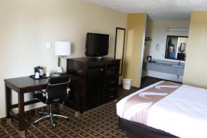 ein Hotelzimmer mit einem Bett und einem Schreibtisch mit einem TV in der Unterkunft Quality Inn - Conway in Conway