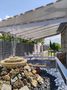 eine Terrasse mit einem Brunnen und einem Sonnenschirm in der Unterkunft Harmony Sophie's in Néon Rýsion