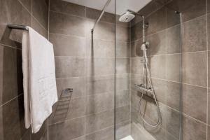 baño con ducha y puerta de cristal en NH Luxembourg, en Luxemburgo