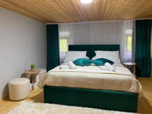a bedroom with a large green bed with blue pillows at Guesthouse Bec Villi in Theth +19 photos