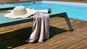 einen Hut und Handtücher auf einem Tisch neben einem Pool in der Unterkunft A Machja in Olmiccia