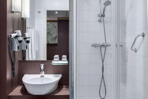 uma casa de banho com um chuveiro com um lavatório e um chuveiro em NH Centre Utrecht Hotel em Utrecht