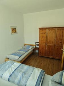 um quarto com 2 camas e um armário de madeira em FeWo Kronsberg em Eldingen