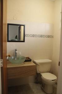 a bathroom with a sink and a toilet and a mirror at Amplia Casa en Sector Viñedos (factura) in Torreón