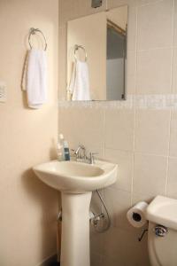 a bathroom with a sink and a mirror and a toilet at Amplia Casa en Sector Viñedos (factura) in Torreón