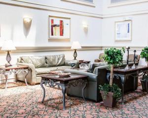 un ampio soggiorno con divano e tavoli di Comfort Suites McAlester a McAlester