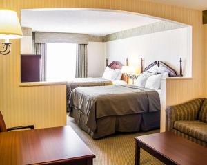 ein Hotelzimmer mit 2 Betten und einem Stuhl in der Unterkunft Comfort Suites McAlester in McAlester