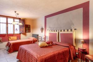 a bedroom with two beds with a dog laying on the bed at Ca' Pavaglione Country House in Borgomale