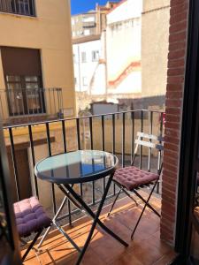 Una mesa de cristal y dos sillas en un balcón. en Encantador apartamento Enlosado de Balborraz, en Zamora