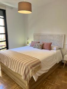 Un dormitorio con una cama grande con almohadas. en Encantador apartamento Enlosado de Balborraz, en Zamora