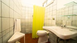 a bathroom with a yellow shower curtain and a sink at Taormina Hotel Calipso in Mazzeo