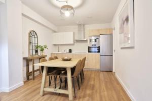 a kitchen and dining room with a table and chairs at El Balcón de Jauregui centro in Salamanca
