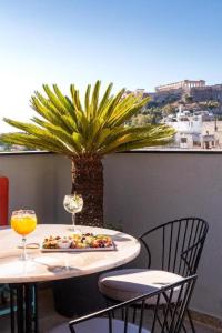 Athens Ivy Suites في أثينا: طاولة مع صحن من الطعام و نخلة