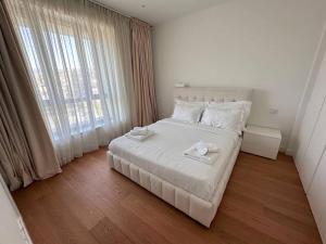 リマソールにあるDel Mar Beachfront 3 Bedroom 'A' Residenceの白いベッドと大きな窓のある寝室