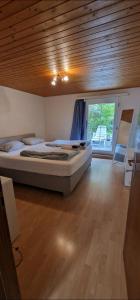 a large bed in a room with a wooden ceiling at Garden Eden in Freienbach