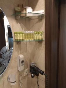 een badkamer met een spiegel en een telefoon aan de muur bij Archontopetra Boutique Hotel in Méga Khoríon