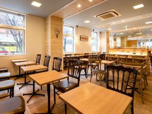 un restaurante con mesas y sillas de madera y un bar en Comfort Hotel Saga en Saga