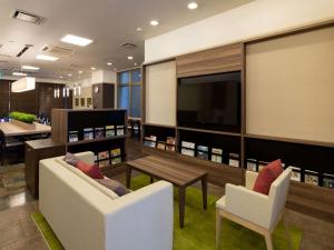 uma sala de estar com duas cadeiras e uma mesa e uma televisão em Comfort Hotel Yamagata em Yamagata