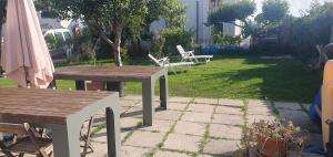 un patio con 2 mesas de madera y sillas en Simpatico appartamento autonomo sul mare en Termoli