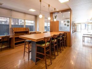 Comfort Hotel Shin Yamaguchi في ياماغوتشي: غرفة طعام مع طاولة وكراسي خشبية كبيرة